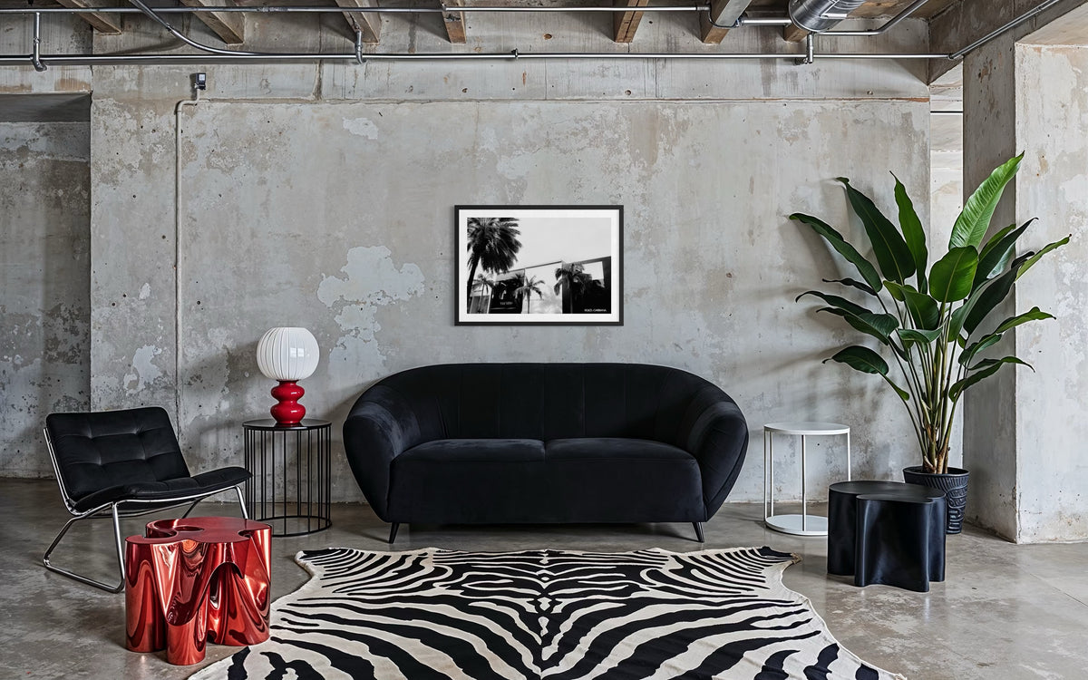 Black sofa and zebra rug in loft apartment with concrete walls, Beverly Hills, California.