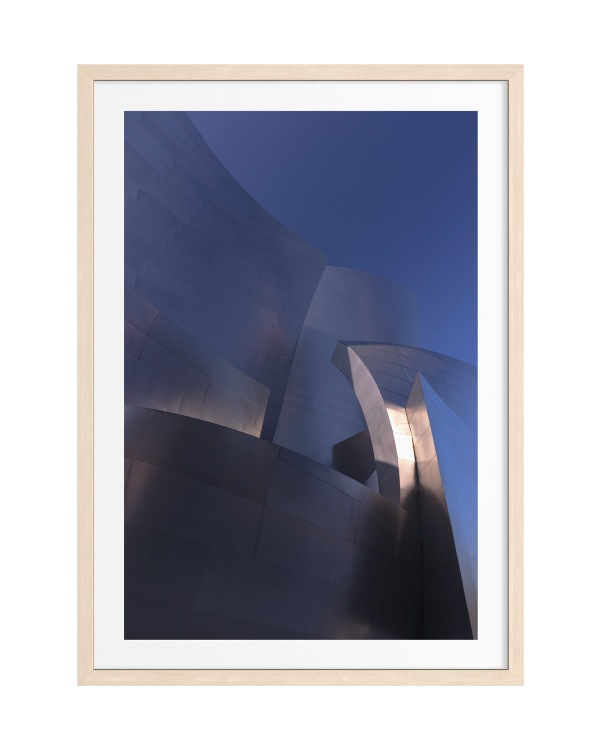 Curved metallic facade of a Gehry building reflecting soft light, print in a light wood frame.