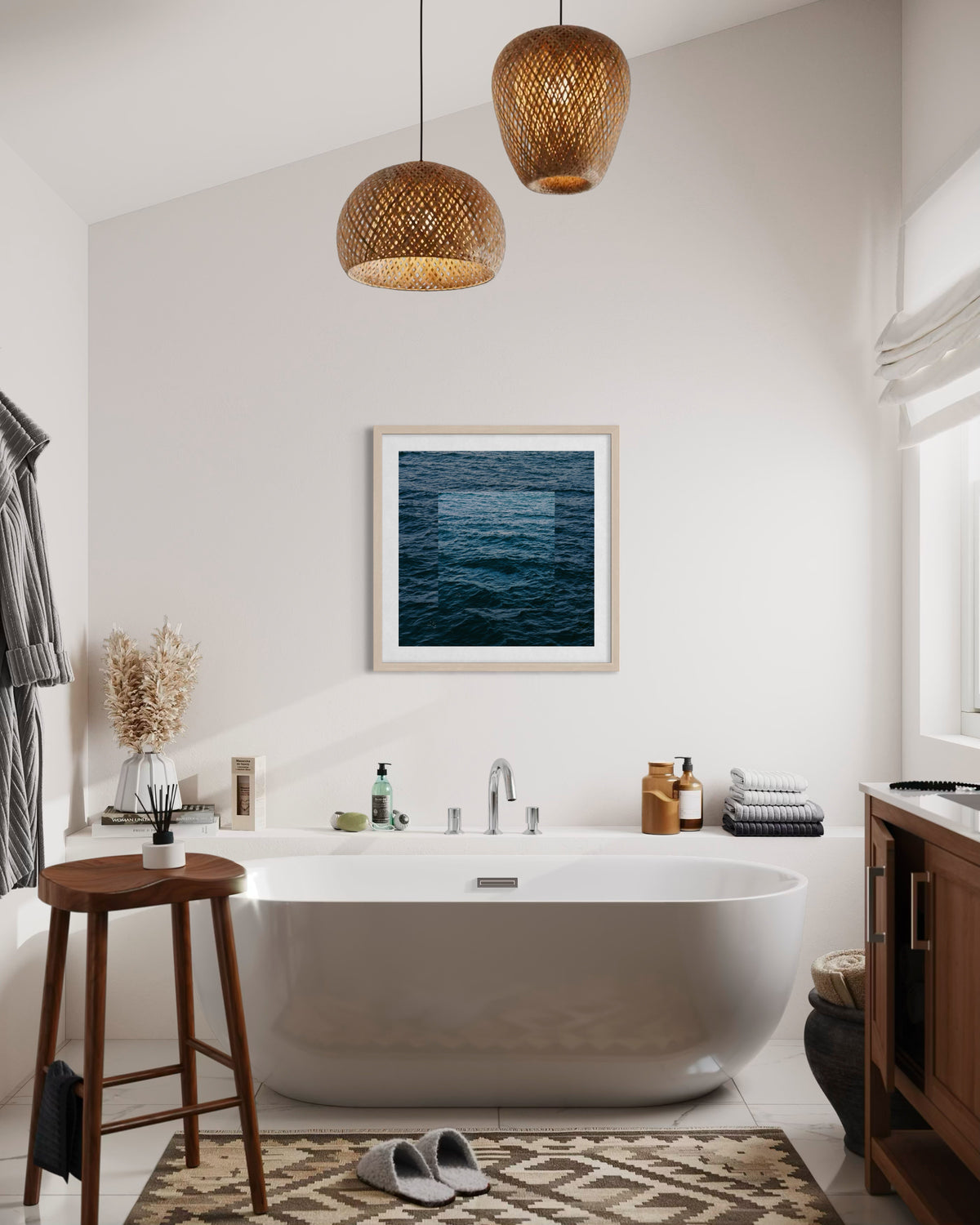 White bathtub with a wooden stool, pendant lights, and “Blue Ocean” art above in a modern bathroom setting.