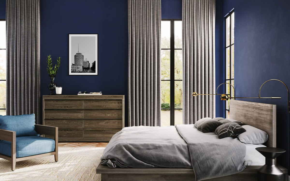 Photograph of the Capitol Records Building in Los Angeles, displayed above a wooden bed with navy walls.