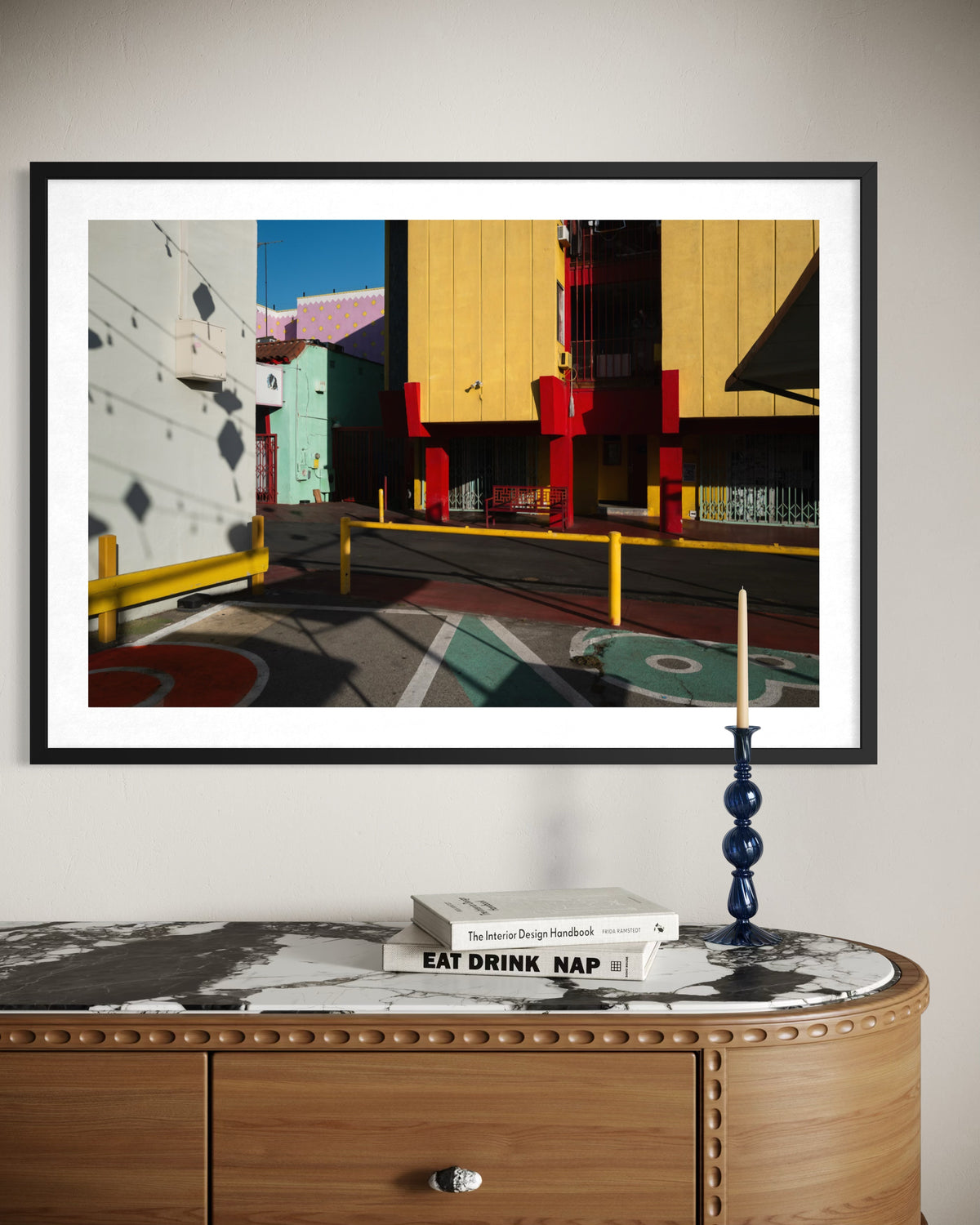 Colorful Chinatown Study artwork with shadows above marble table, books, and a blue candlestick in New York City.