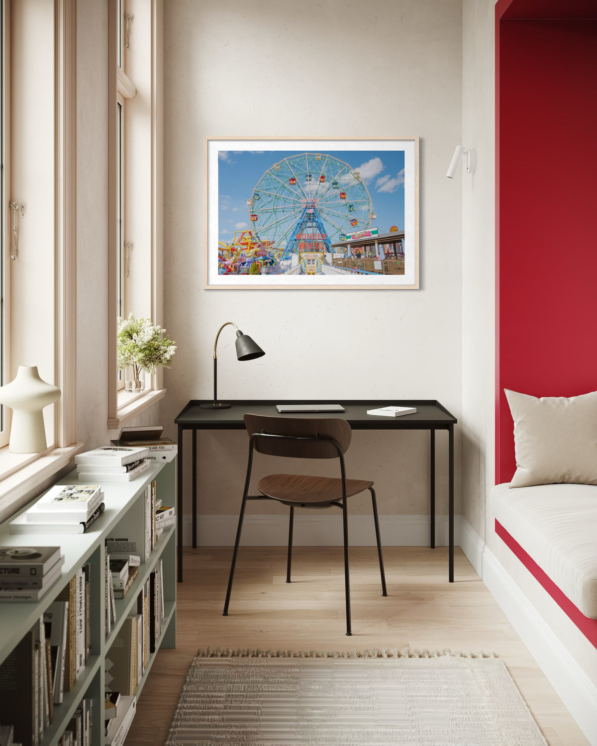 Black desk and wooden chair beneath a Coney Island Wonder Wheel photograph on the wall.