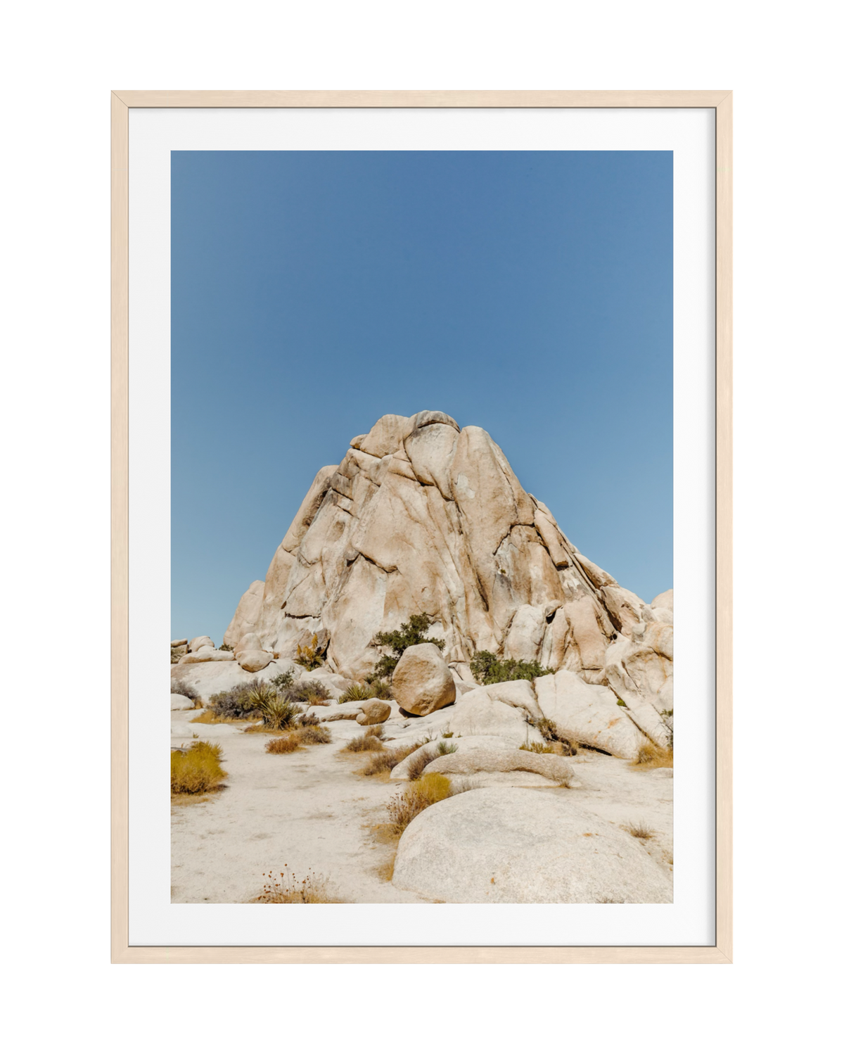 Framed print of a dramatic desert rock formation beneath a wide blue sky. Location unspecified.