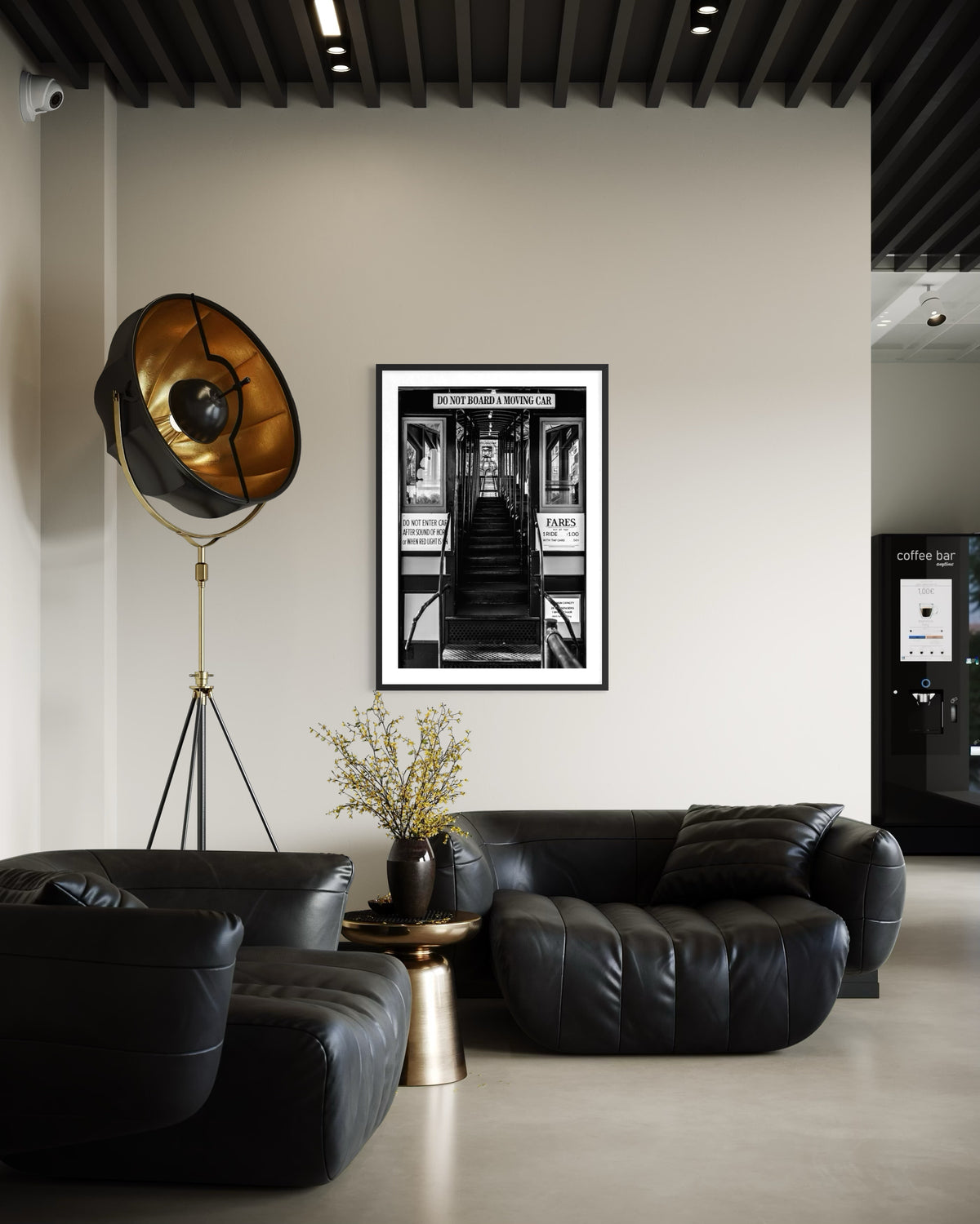Black sofas and gold floor lamp in a living room, with DTLA Funicular Passage photograph on the wall.