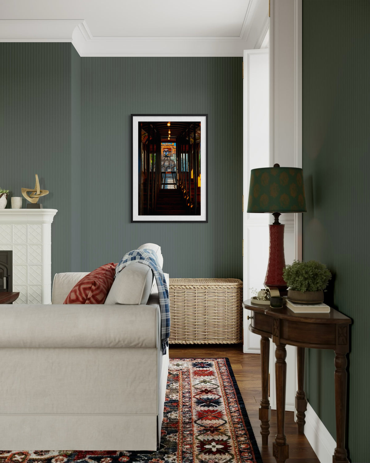 Los Angeles living room with green walls, white sofa, and “DTLA Funicular” artwork above a wicker chest.