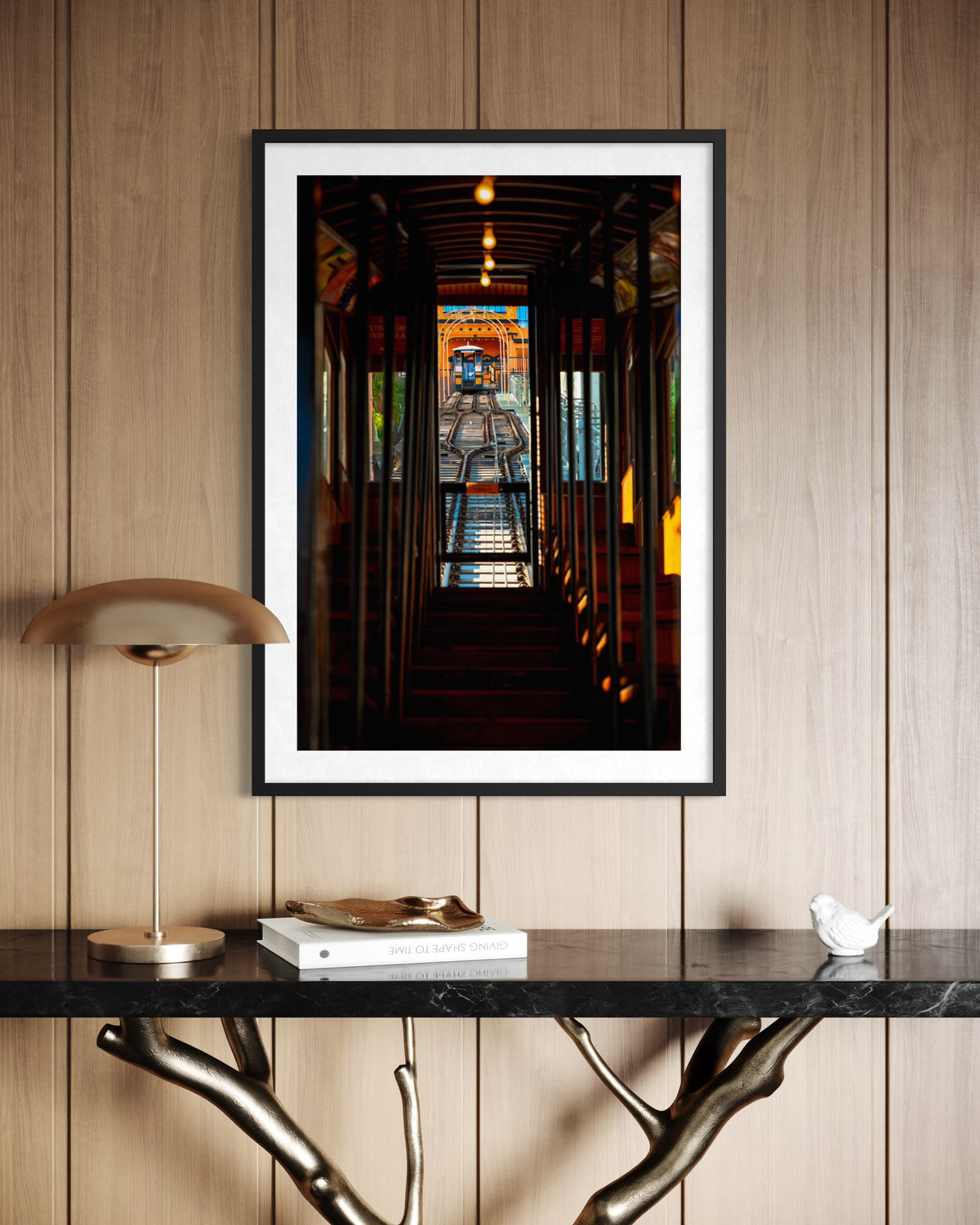 Framed photo of Los Angeles’ historic DTLA funicular hangs above a wooden console against a wood-paneled wall.