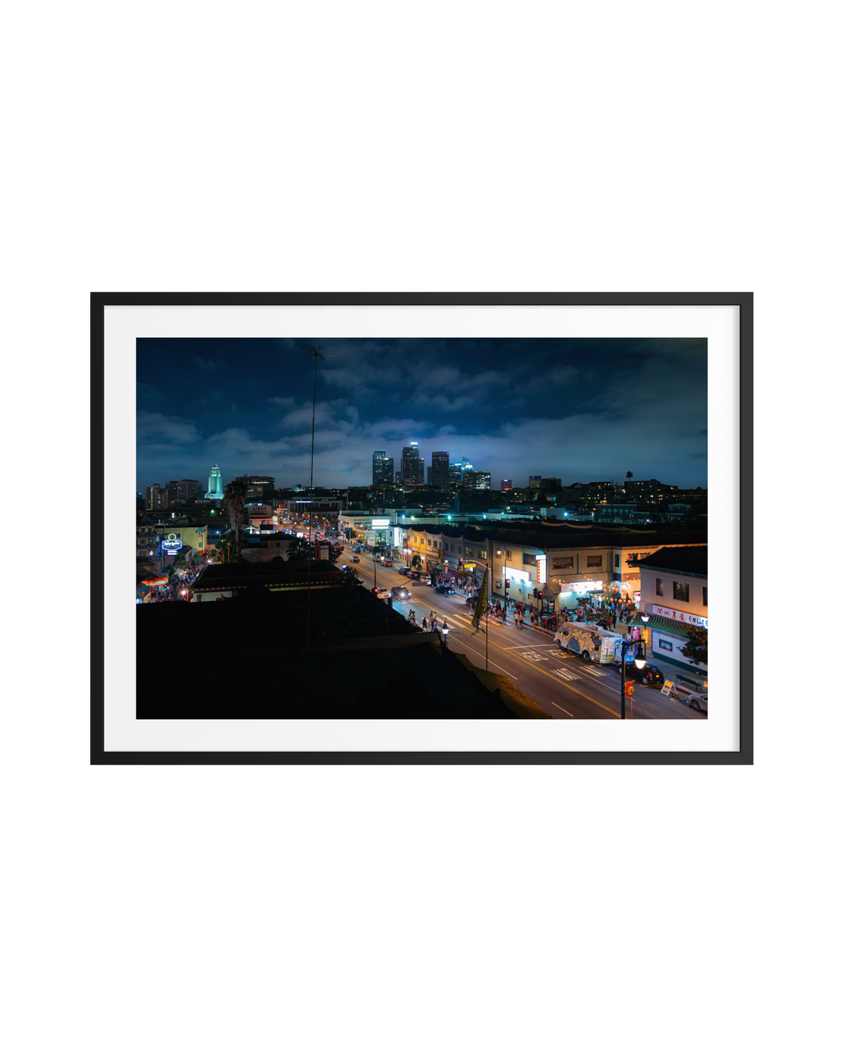Downtown Los Angeles at night with bright city lights, busy streets, and tall buildings against the dark sky.