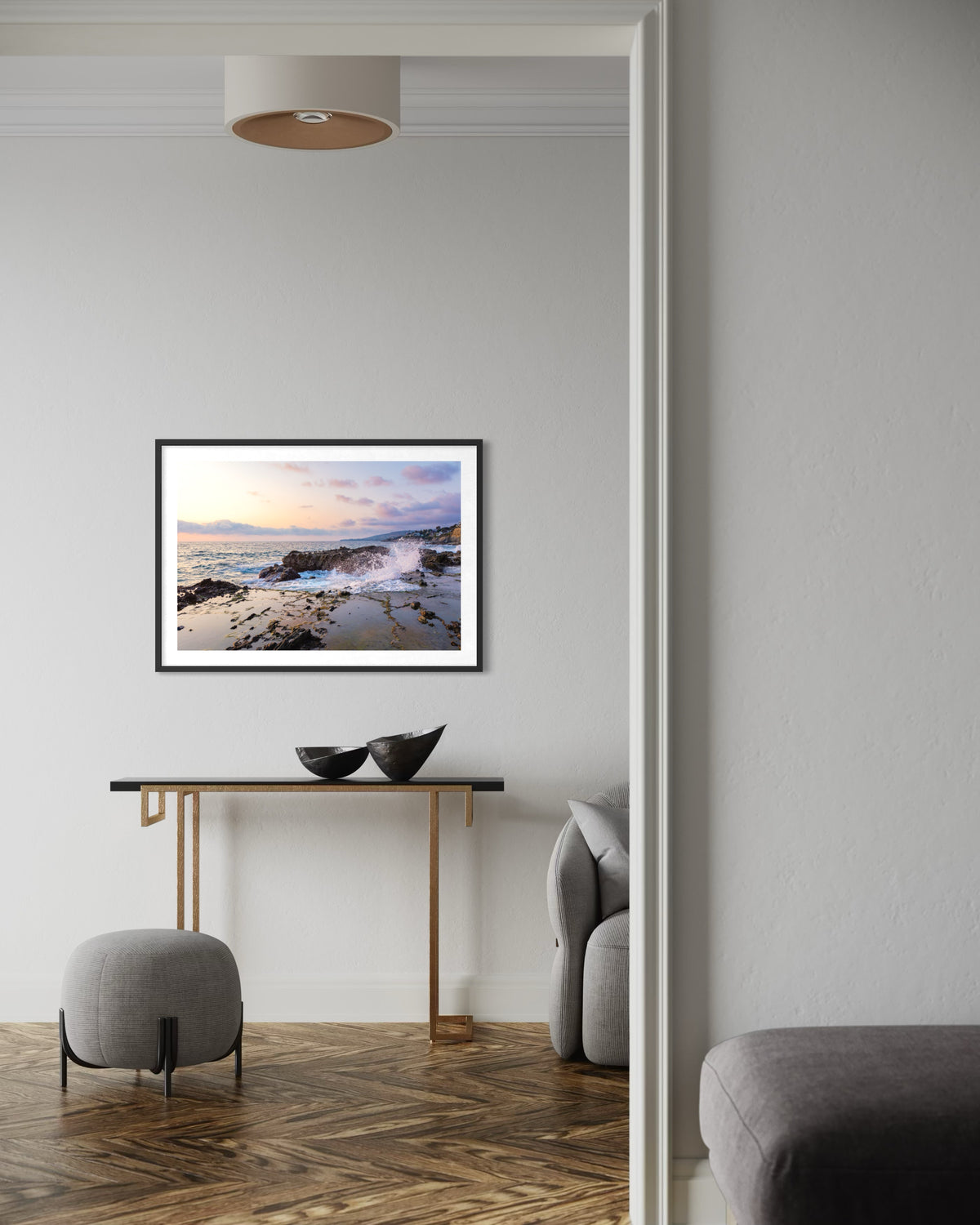 Framed “Evening Splash” print on white wall above console table with two bowls in a minimalist living room.