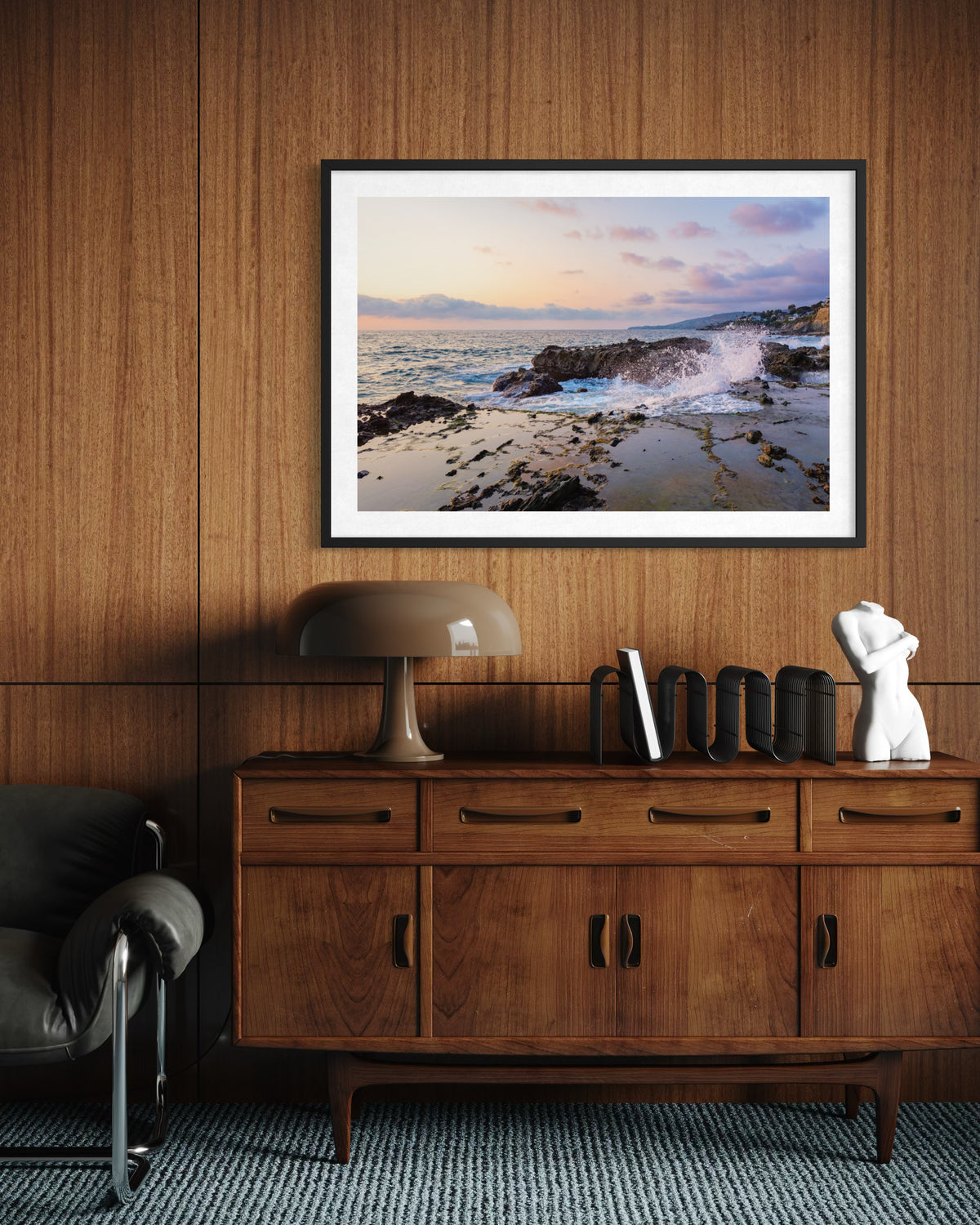 Evening Splash artwork featuring a coastal scene hangs above a wooden sideboard in a Laguna Beach home.