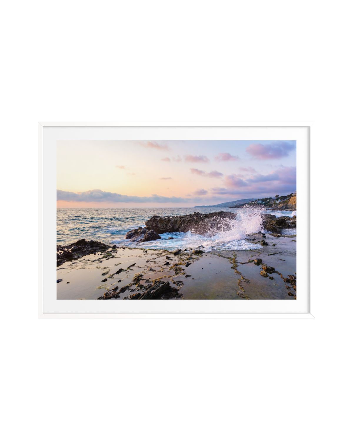 Sunset waves hit rocks on Laguna Beach, with pink clouds above a calm sea. Framed photography print.