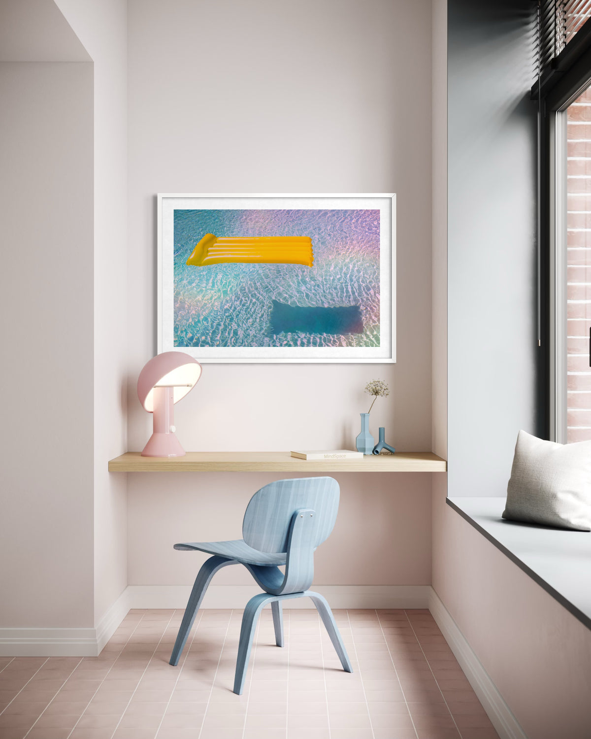 Desk with blue chair, pink lamp, and “Floating Through Summer” print of a swimmer above.