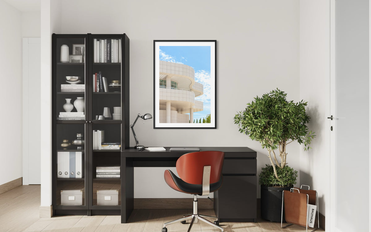 Black desk and red chair in Los Angeles home office featuring Getty Center architecture decor.