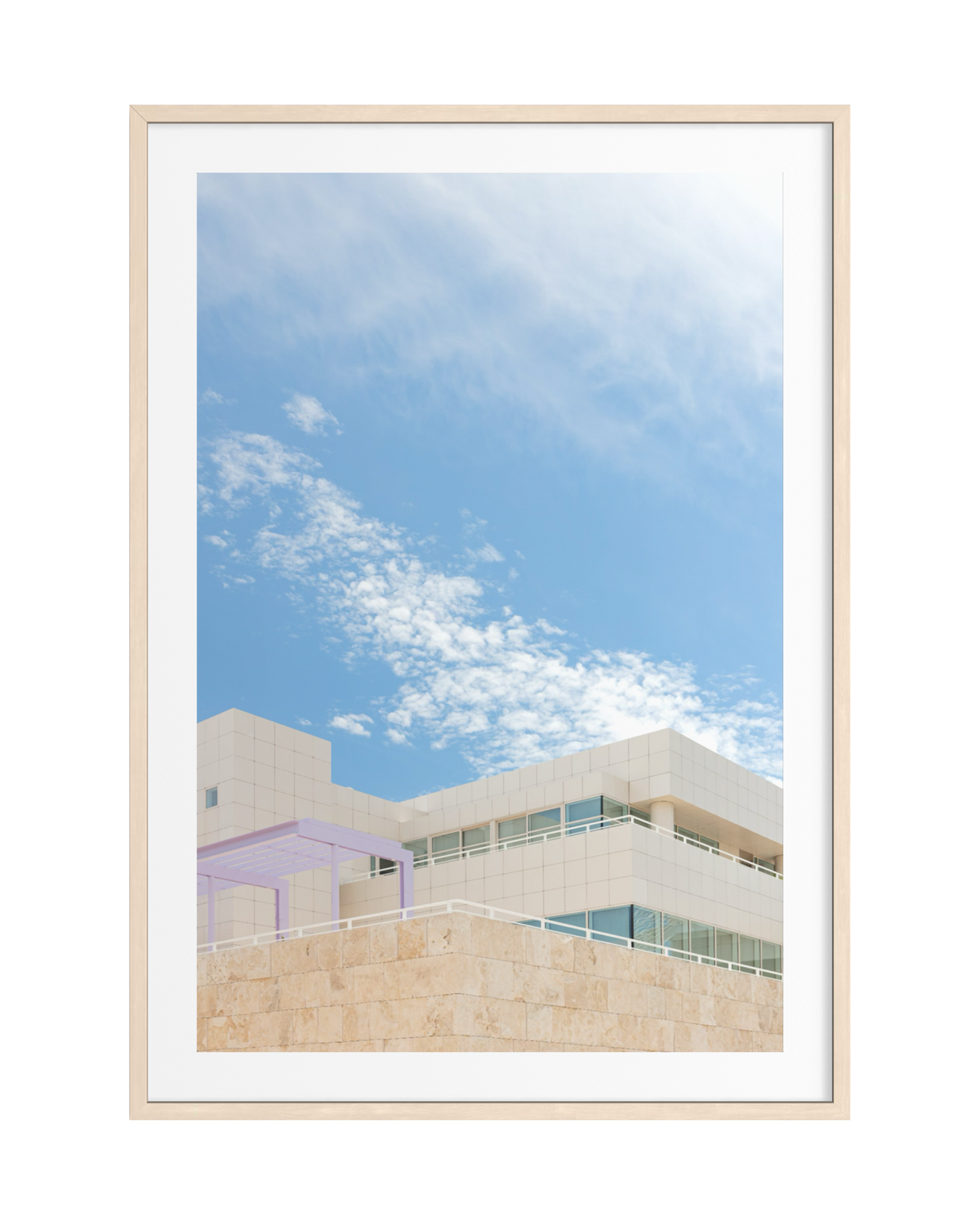 Beige and white travertine building at the Getty Center, Los Angeles, beneath a blue sky, framed in light wood.