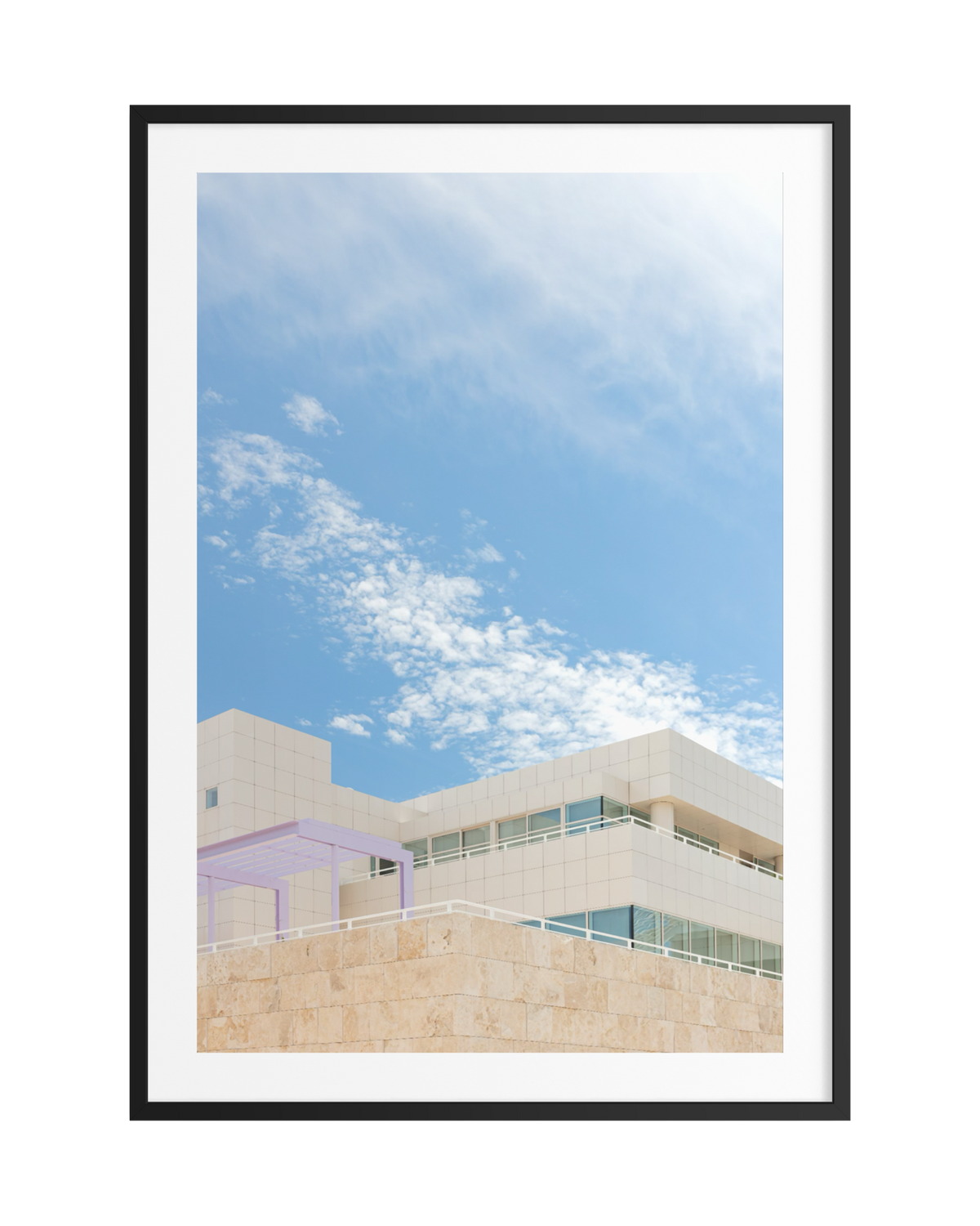 Modern white architecture and travertine at the Getty Center, Los Angeles, with large windows and wispy clouds, black frame.
