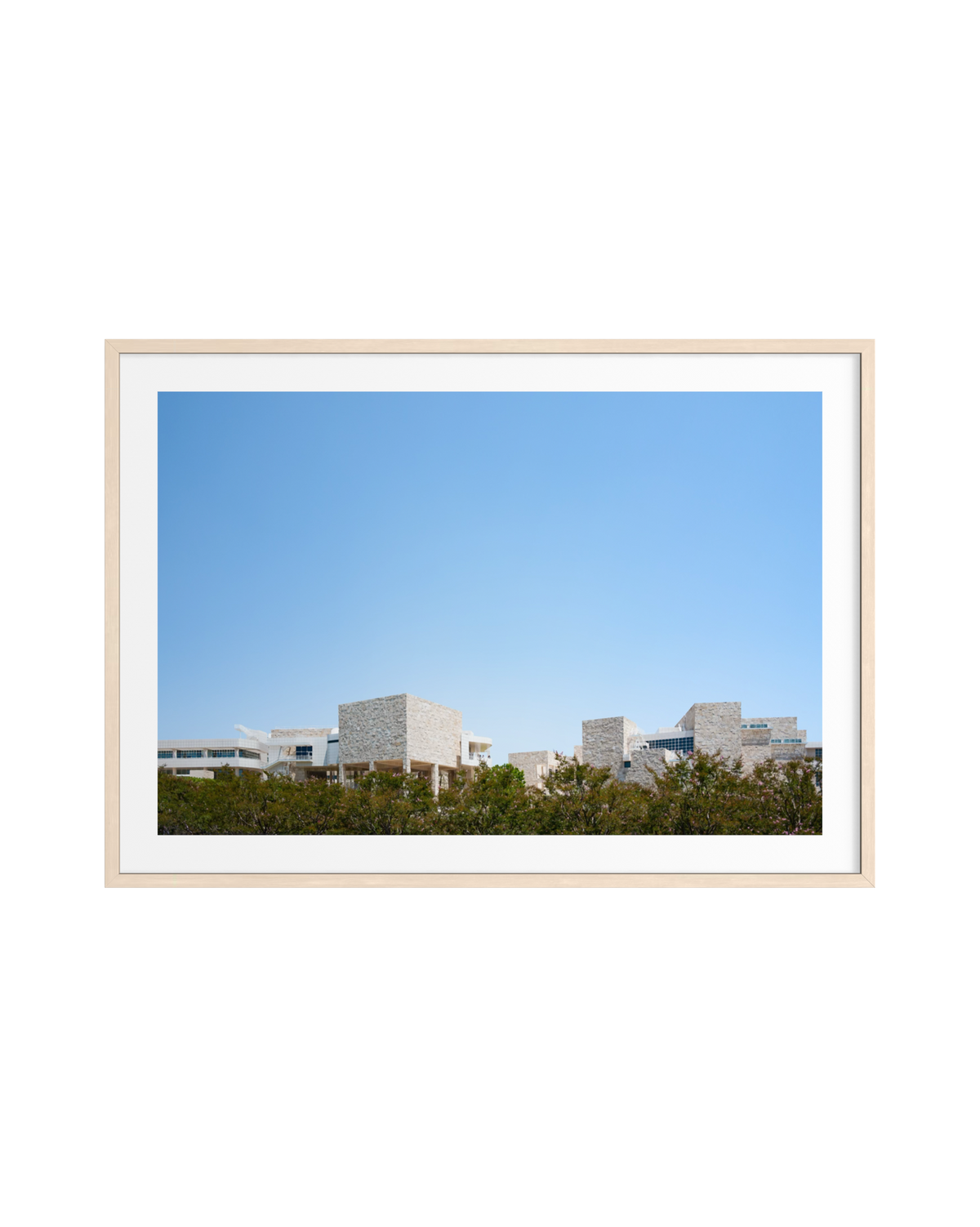 Framed print of the Getty Center’s modern architecture and lush greenery under a clear sky, centered on white.