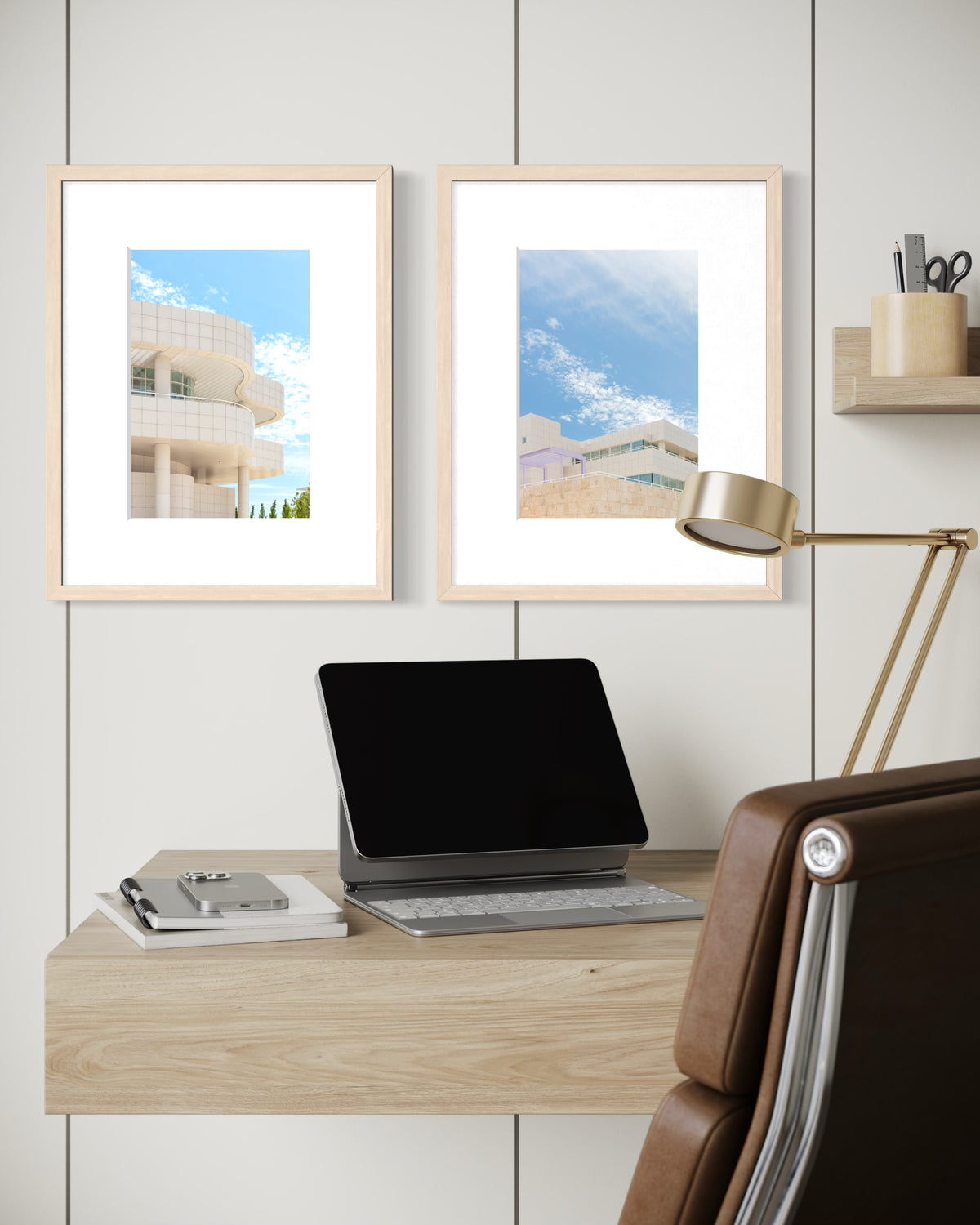 Framed Getty Center Pairing photograph above a desk with laptop and lamp in a minimalist office setting.