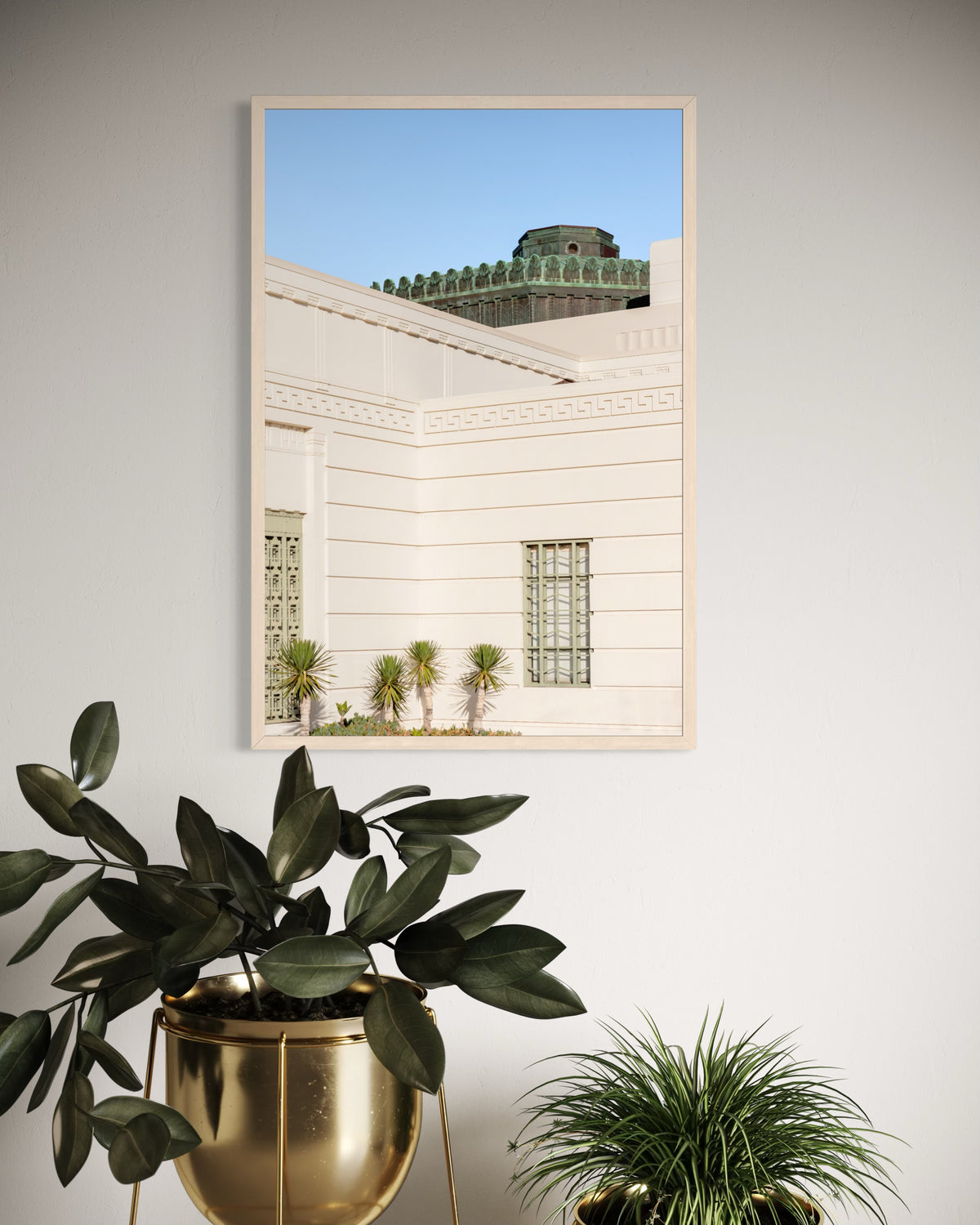 Art Deco Griffith Observatory in Los Angeles with green potted plants against a light wall in foreground.