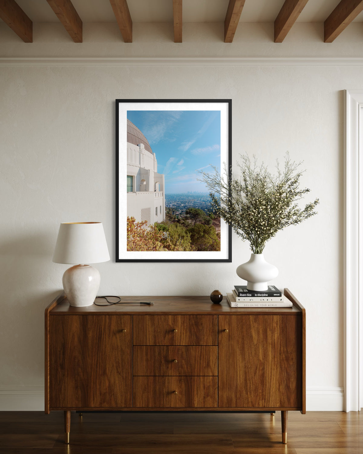 Griffith Observatory photograph displayed above a mid-century console with a lamp and vase, Los Angeles.