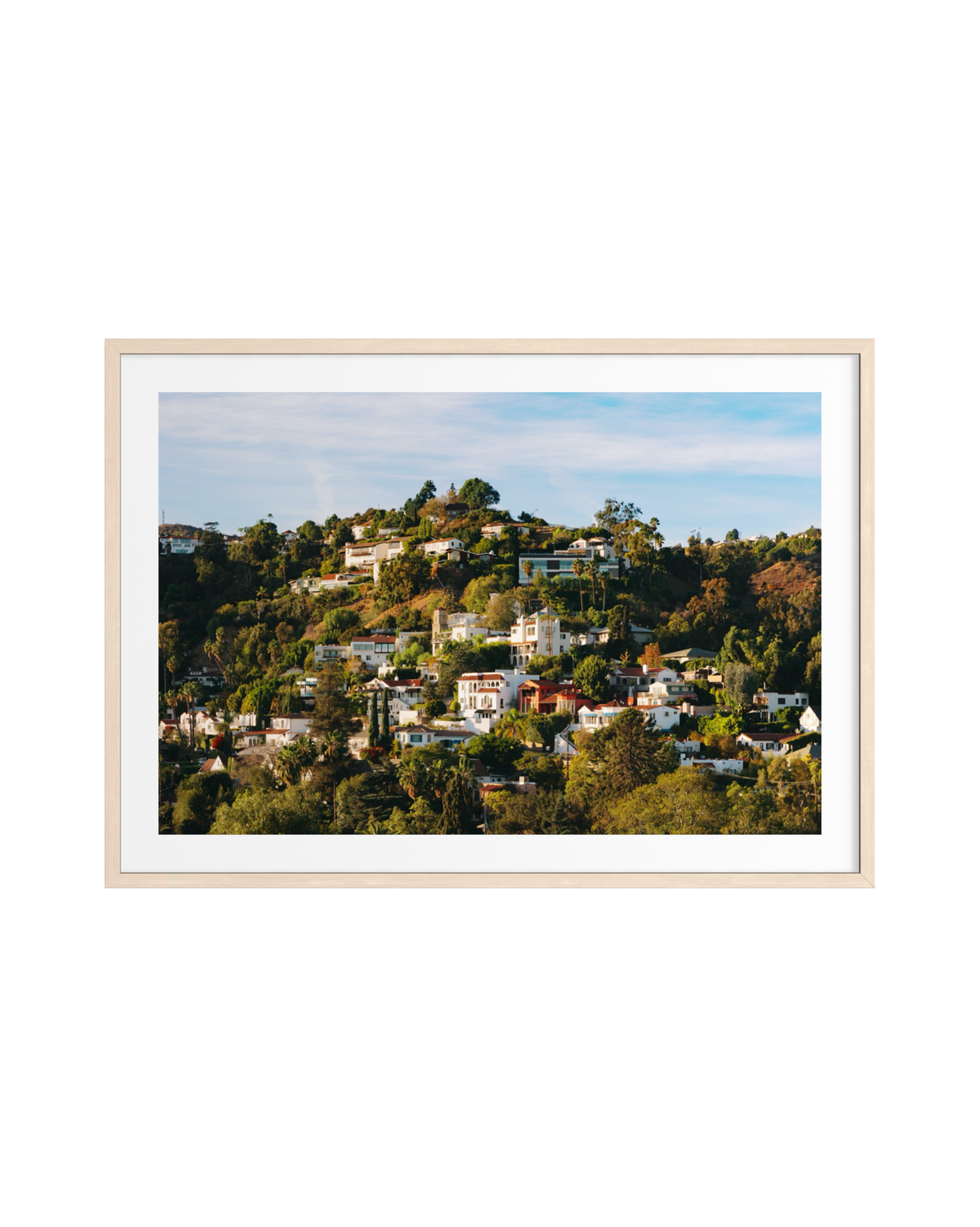Colorful houses on a green hillside under blue sky in Hollywood Hills, shown in a light wood frame with white mat.