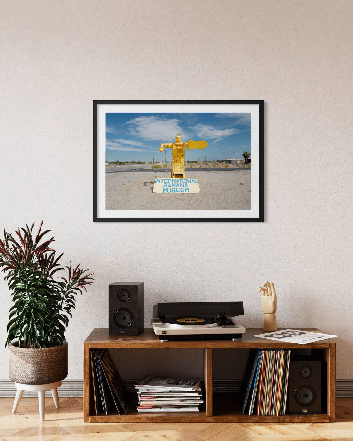 Framed “International Banana Museum” photo displayed above a record player in a Salton Sea-themed room.
