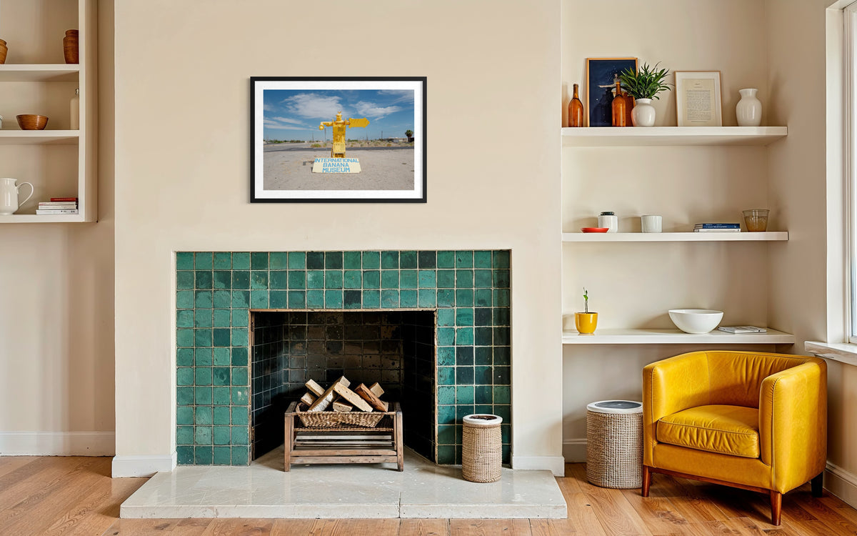 Green-tiled fireplace with a framed cross photo above and International Banana Museum reference in the living room.