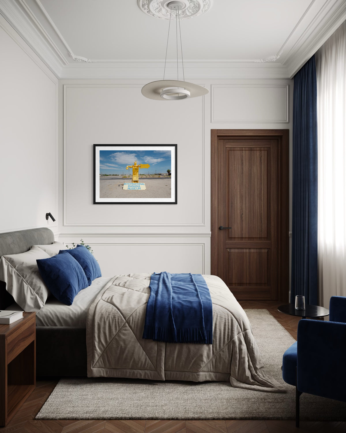 Blue and beige bed, wooden door, and International Banana Museum photo above bed in a modern bedroom.