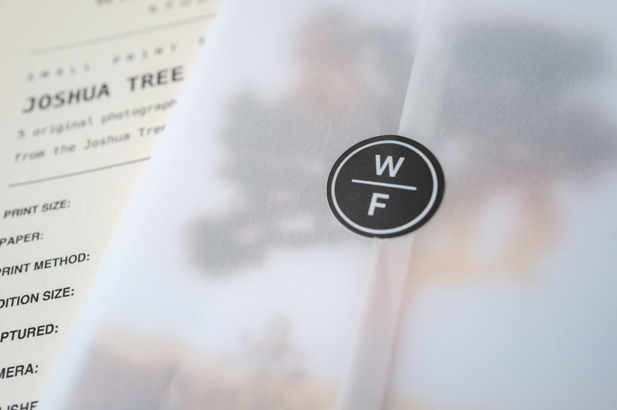 Black WF sticker seals translucent paper around a Joshua Tree desert landscape photo print labeled No. 04.