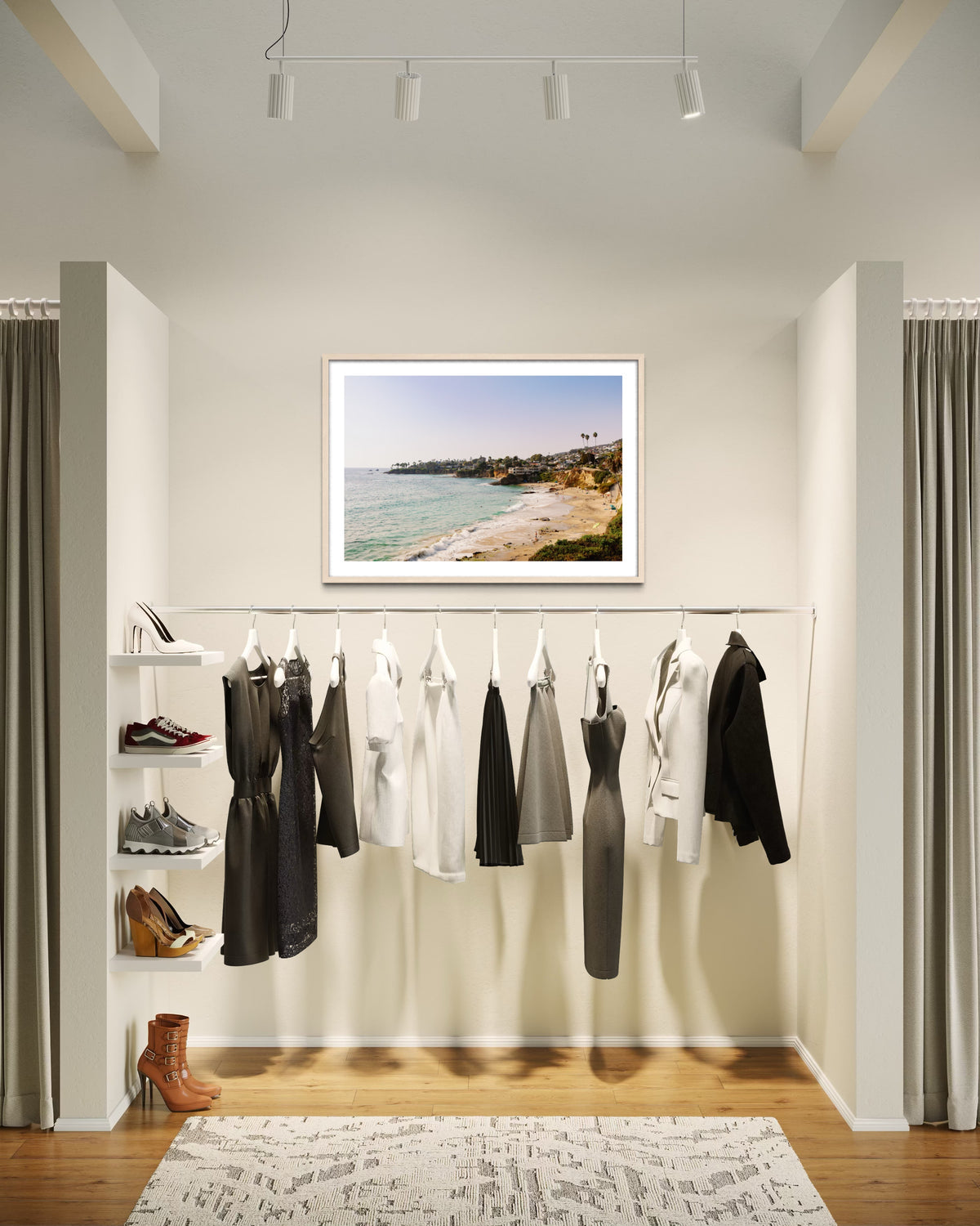 Minimalist closet with neutral and black clothes, shoe shelves, and a “Laguna Beach View” photo above the wall.