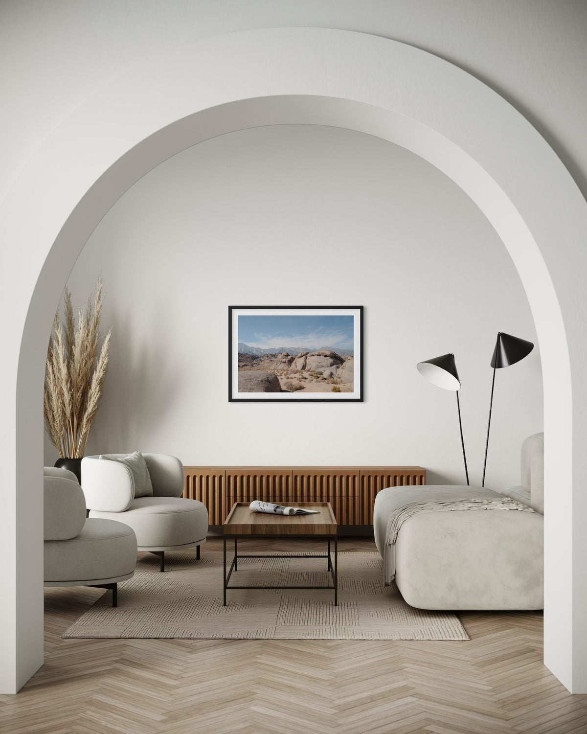 Framed Lone Pine Landscape photograph above white arch in living room with neutral furniture and pampas grass.