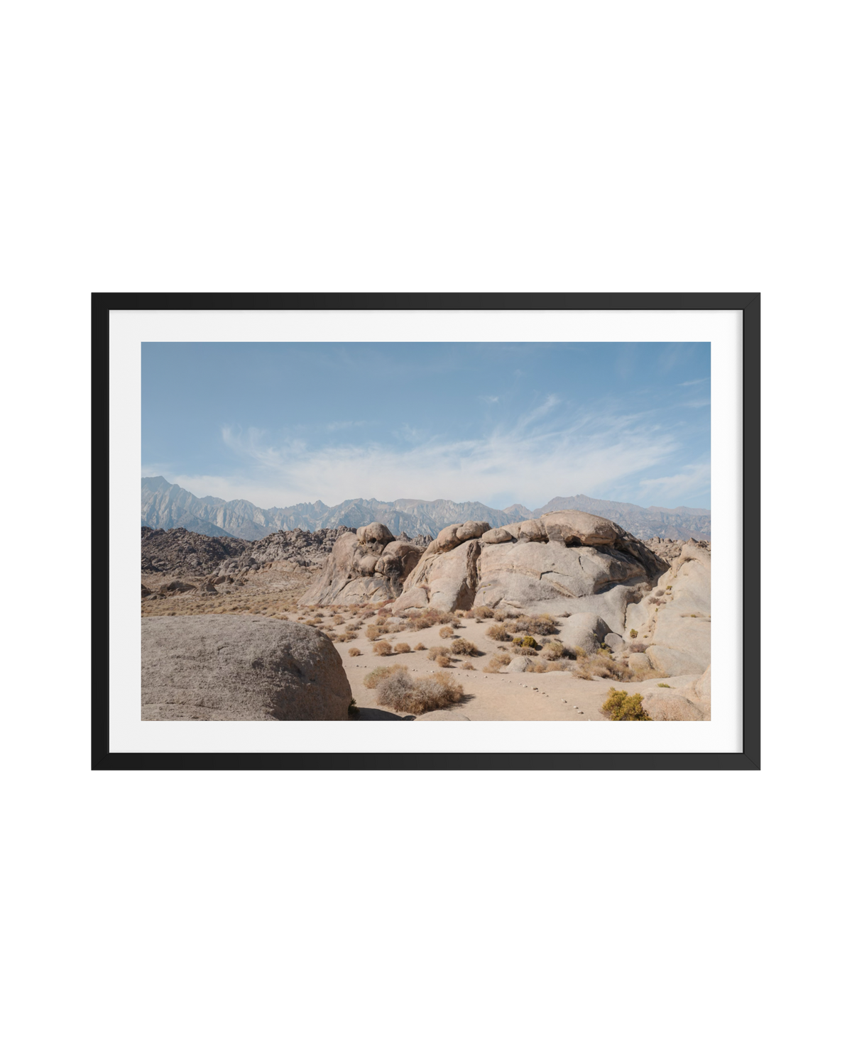 Desert landscape in Lone Pine, California, with rocky terrain, scattered shrubs, and distant mountains.