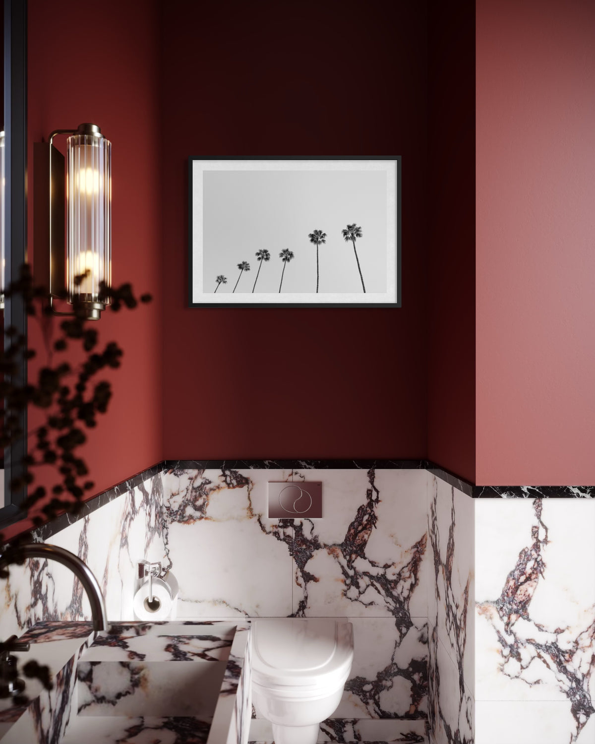 Maroon and marble bathroom with toilet, sink, and framed “Palm Rhythm” photograph on the wall.