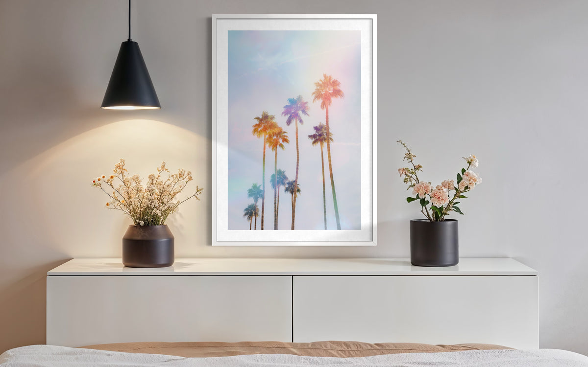 Minimalist dresser with two vases, lamp, and Palm Springs palm tree print art hanging above.