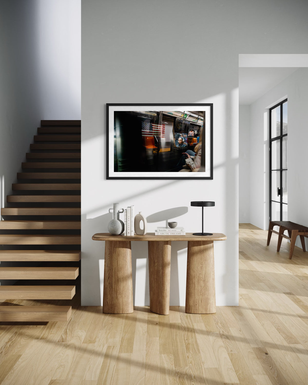 Wooden staircase and console table in a New York City entryway, with “Passing Train, New York City” on the wall.
