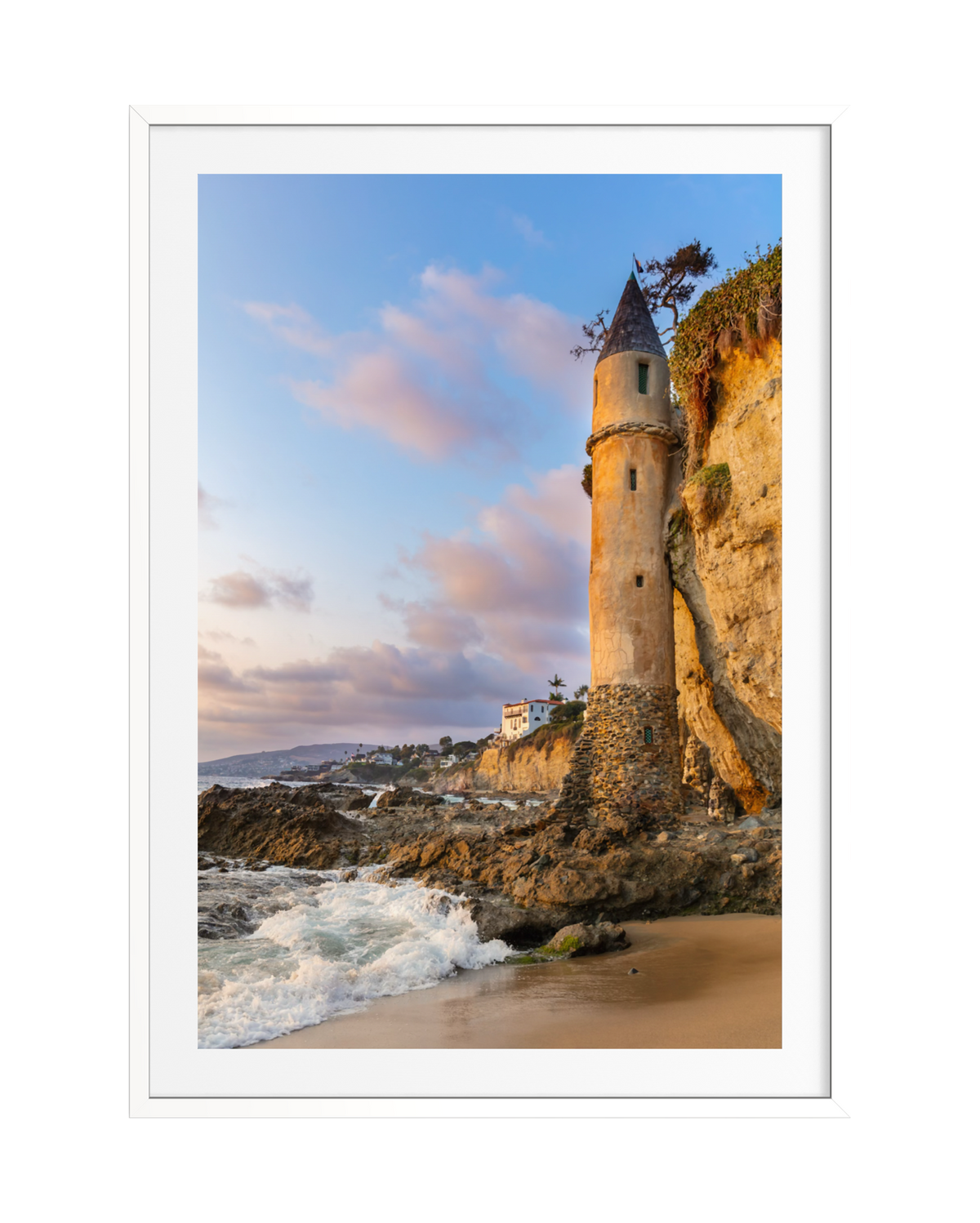 Pirate Tower stands on Laguna Beach cliffs at sunset as waves crash below.