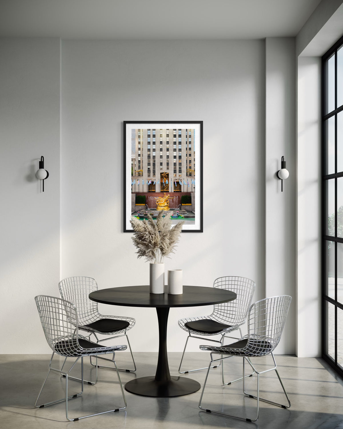 Dining room with round black table, wire chairs, and Prometheus mural at Rockefeller Center, New York.