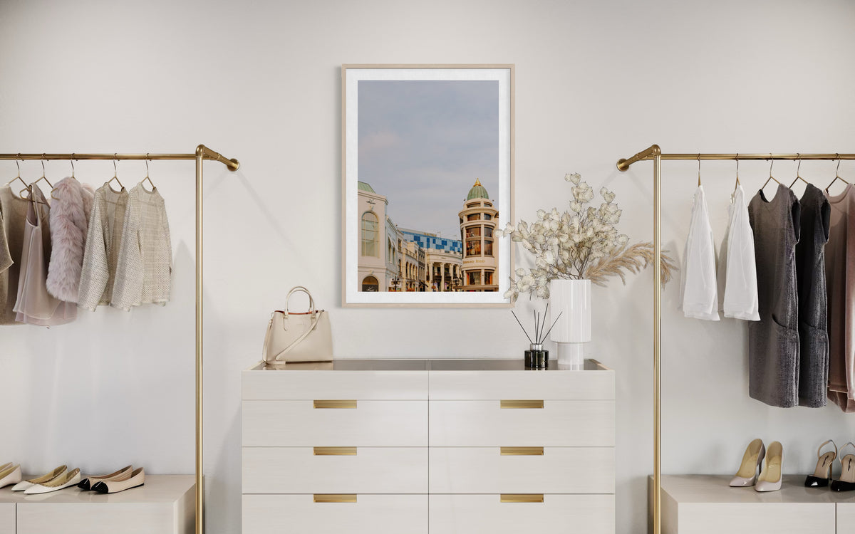 Gold clothing racks and a white dresser arranged in a minimalist Beverly Hills closet.