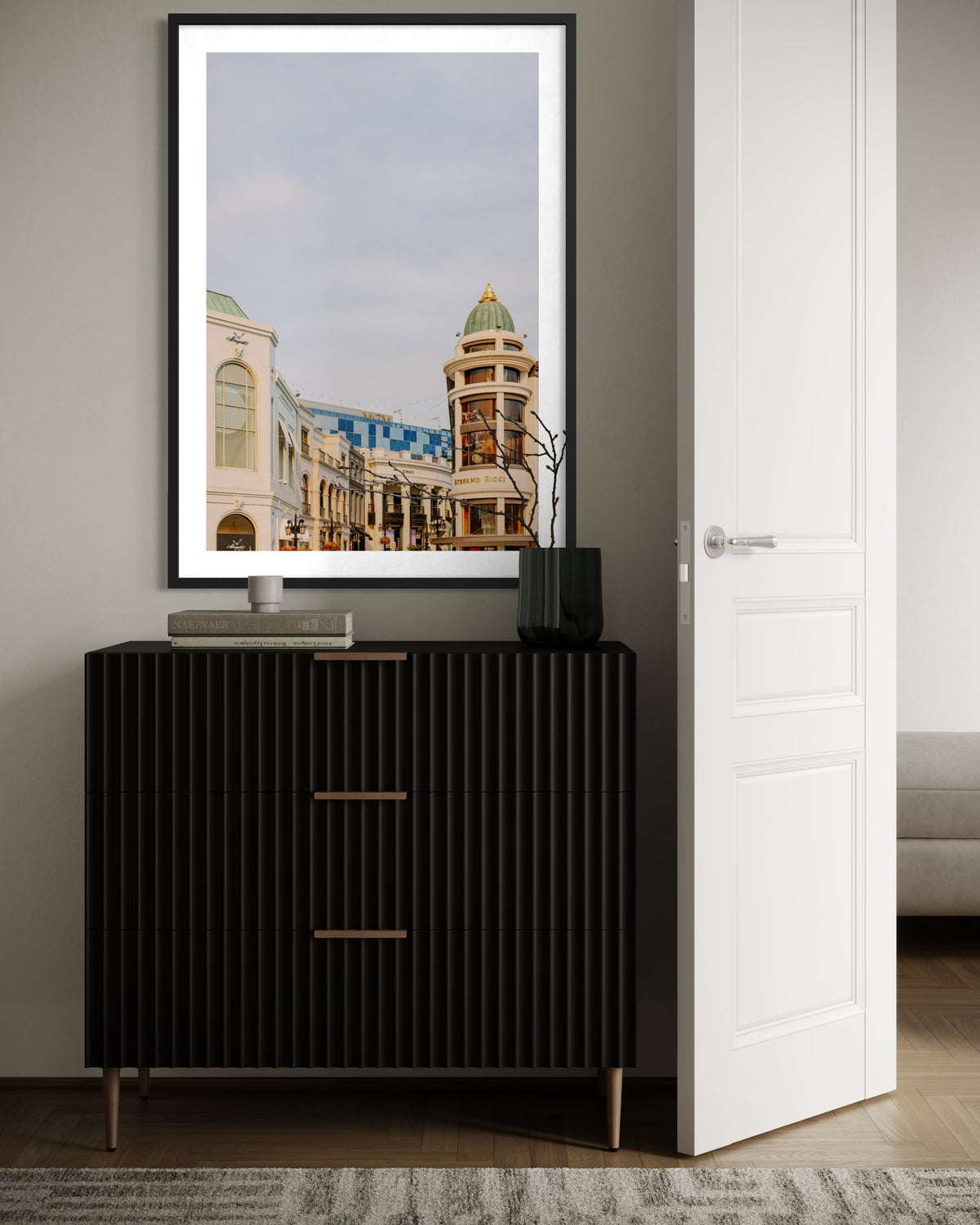 Rodeo Drive cityscape photograph above a black dresser with a vase and book, Beverly Hills, California.