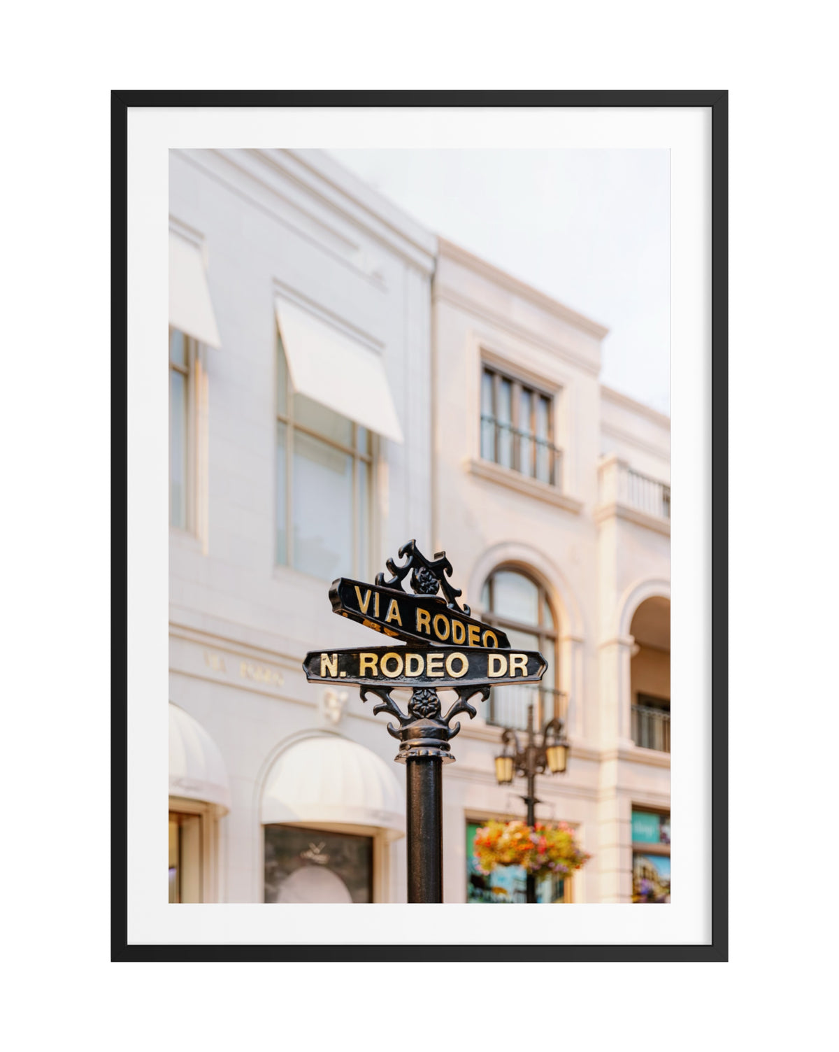 Rodeo Drive street sign in Beverly Hills with white buildings in the background.