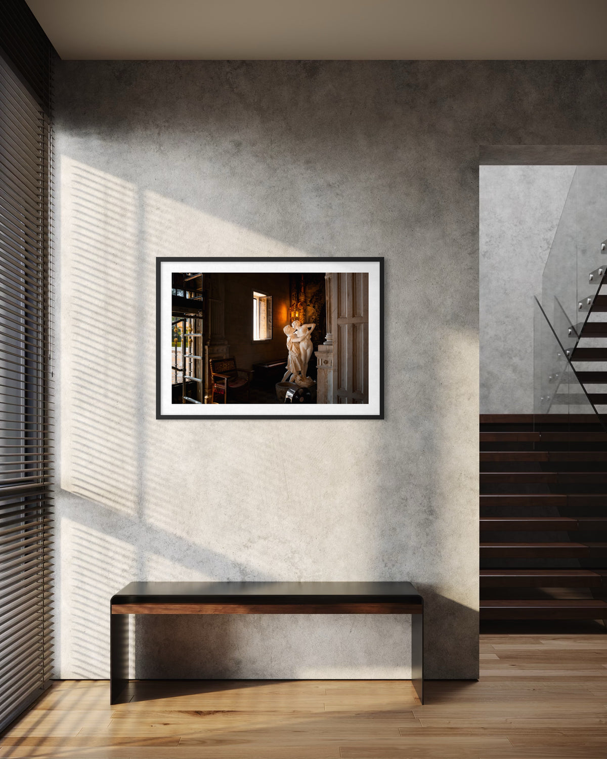 Framed “Stolen Kiss” photo displayed on a gray wall above a bench, modern stairs nearby, warm light illuminating.