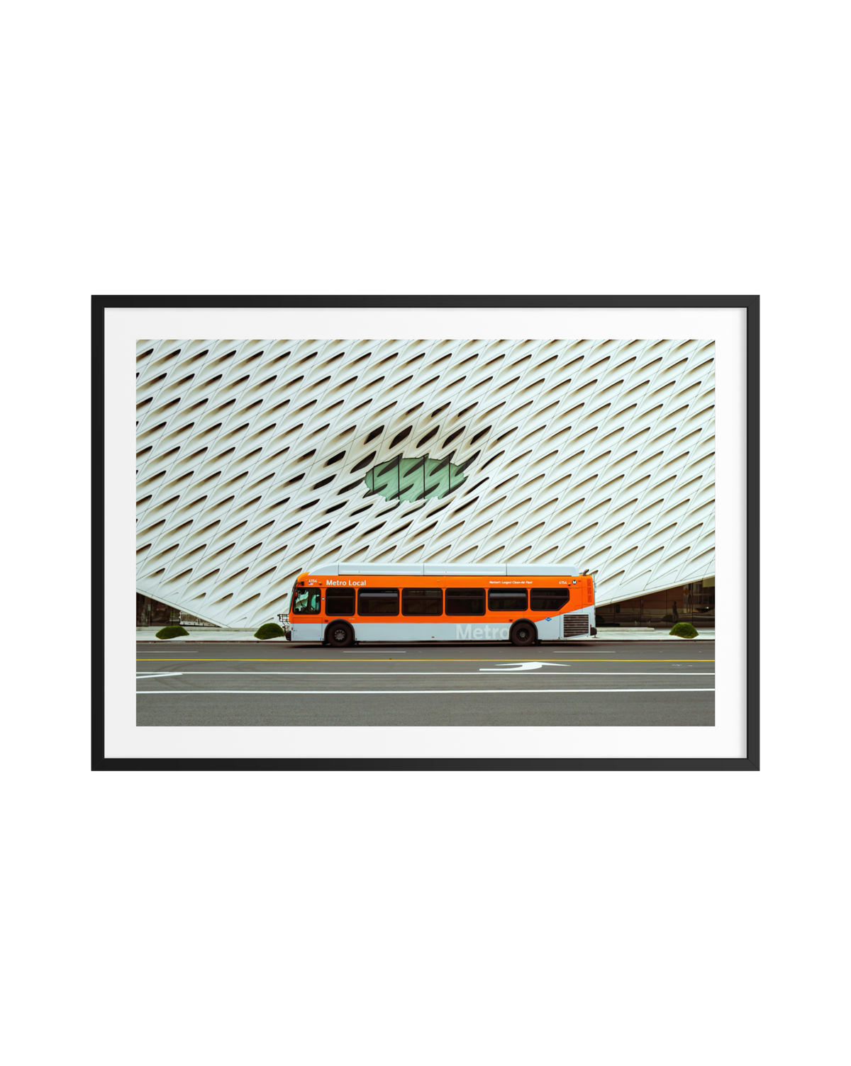 Metro bus passes The Broad museum’s white facade and oval window in downtown Los Angeles.