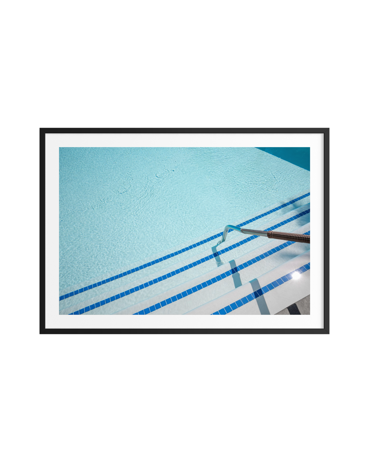 Palm Springs hotel pool with blue water, tiled steps, and metal handrail viewed from above.