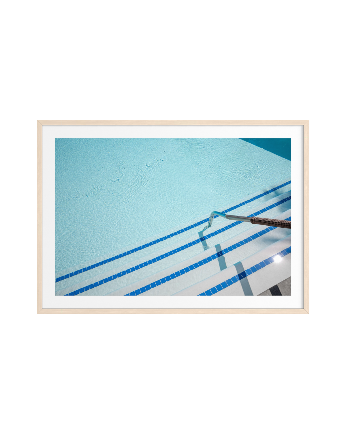 Blue-tiled pool steps and a metal handrail at a Palm Springs hotel swimming pool, outdoors in sunlight.