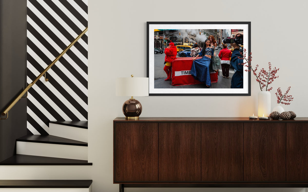 NYC Times Square street scene photograph displayed near stairs in a hallway with a dark wood console and subtle decor.