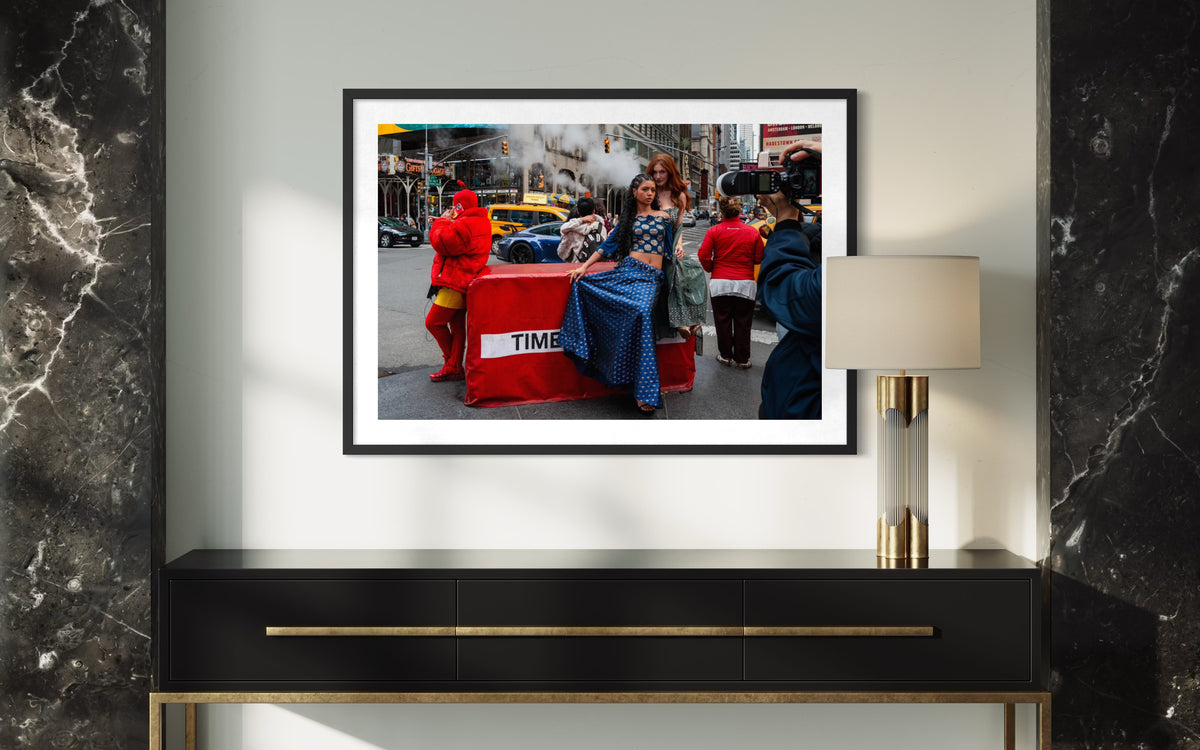 “Times Square Confluence” New York street photo displayed above a black console table with a lamp.