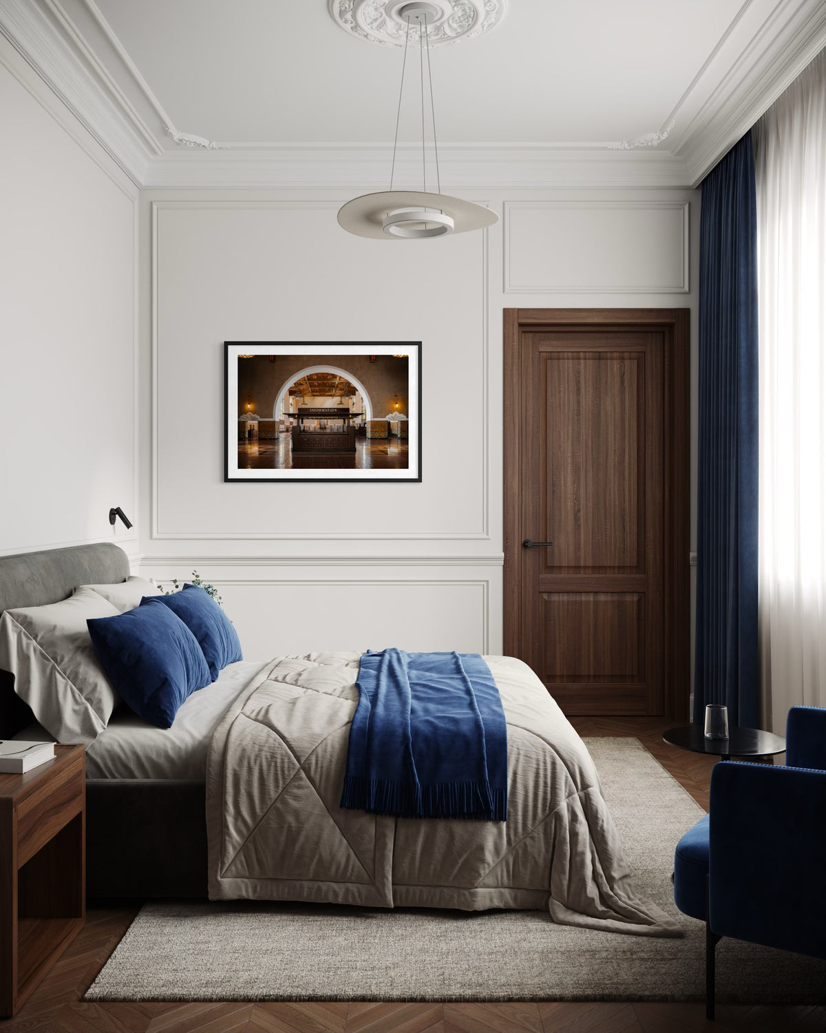 Gray bed with blue pillows beneath a framed Union Station Information art print; modern bedroom interior.
