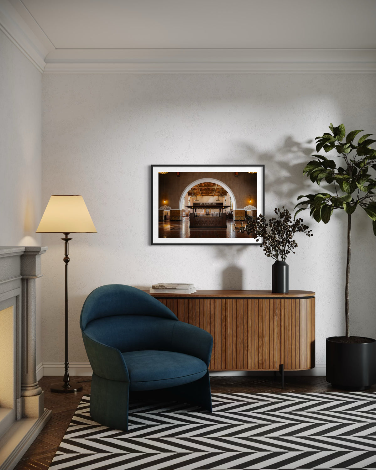 Blue chair and plant in a living room, with a Union Station Information photo from Los Angeles above a wooden sideboard.