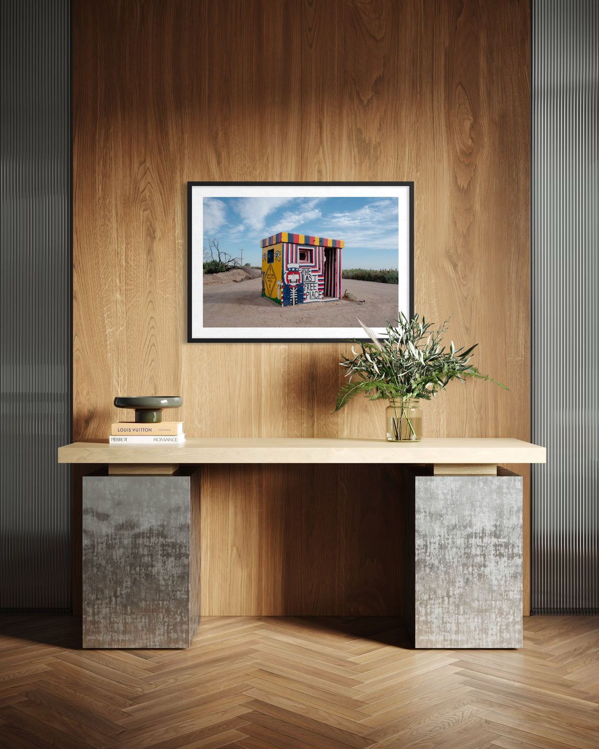 Console table with books, a plant, and “The Last Free Place” wall art on wood-paneled walls.