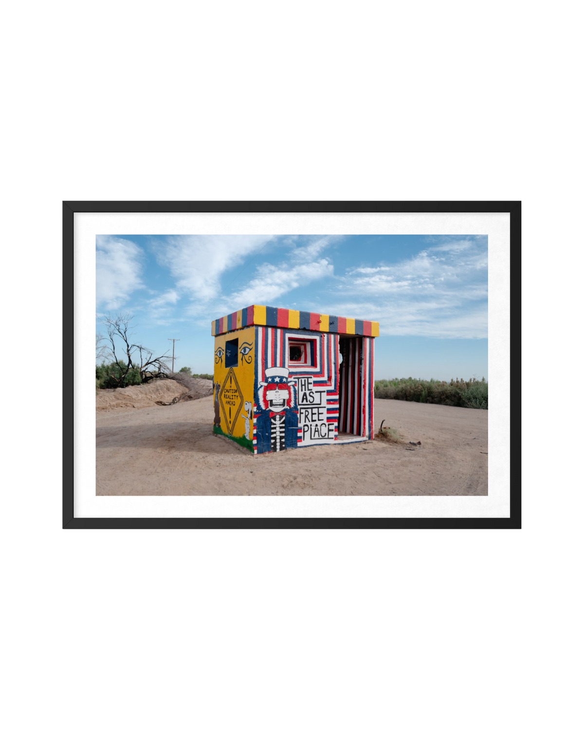 Colorful building in Slab City’s desert under a blue sky with scattered clouds at The Last Free Place.