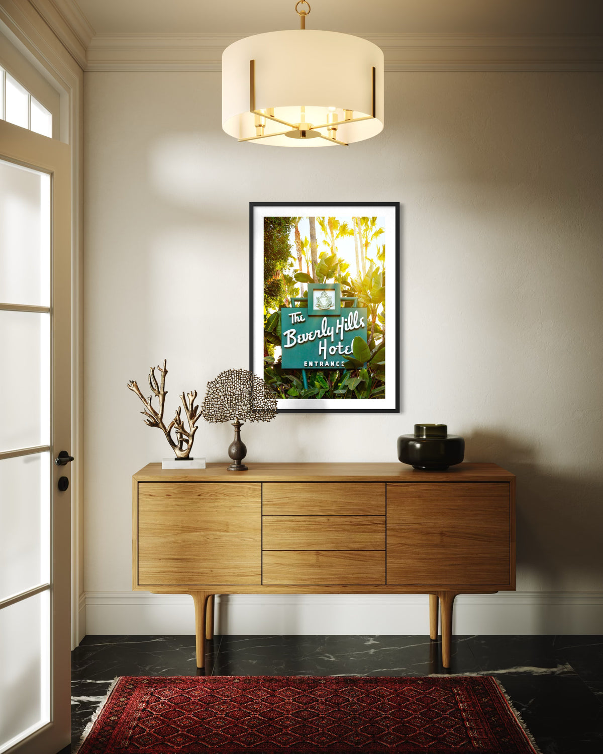 Wood console and pendant light beneath Beverly Hills Hotel sign in a Los Angeles entryway.