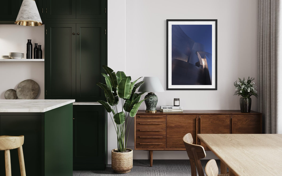 Modern dining area with blue accents, green cabinets, and bold artwork on the walls.